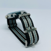 Close-up of black analog watch with striped NATO watch strap