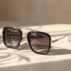 Modern black sunglasses placed on glossy reflective surface