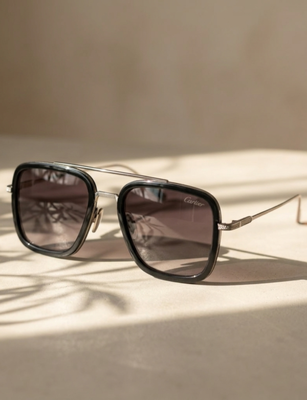 Modern black sunglasses placed on glossy reflective surface