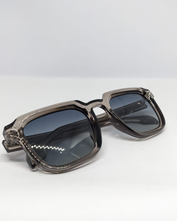 MIGNON FB (5) Close-up of gradient blue-grey tinted lens on square sunglasses