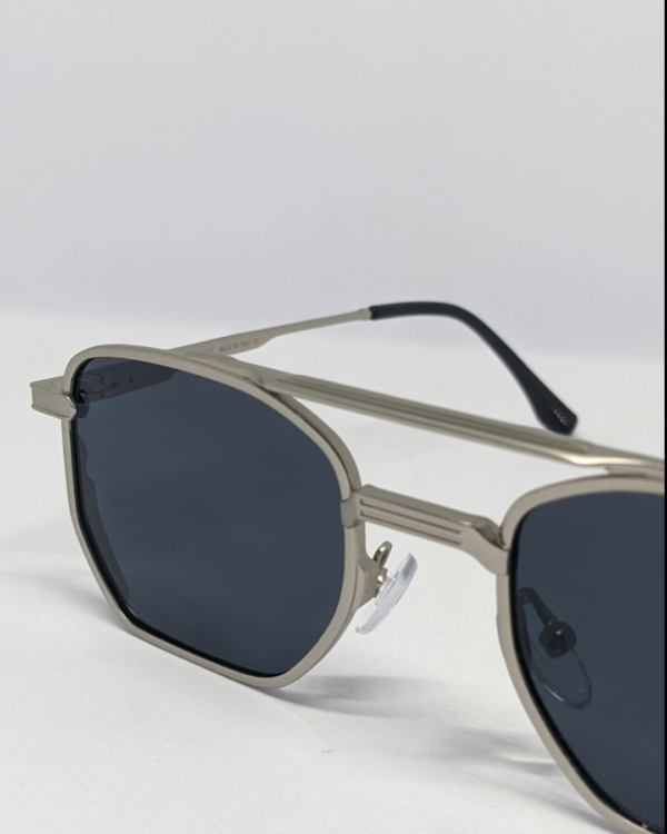 Close-up of dark smoke gray tinted lens on silver aviator sunglasses